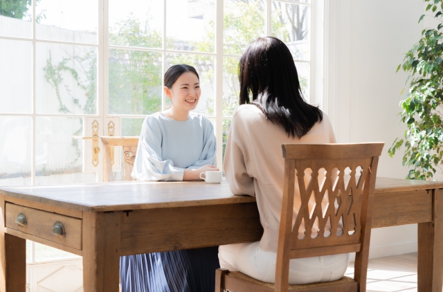 結婚相談所埼玉　２人の女性がテーブルに向かい合って座り、お茶を飲みながら笑顔で会話をしている画像です。