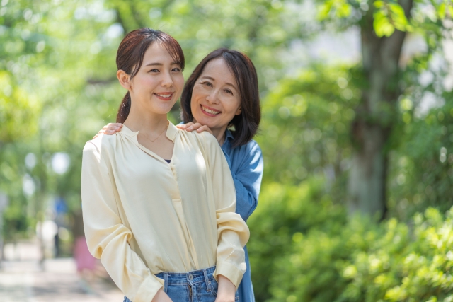 結婚相談所埼玉　娘の両肩に手を置き笑顔の母娘の画像です。