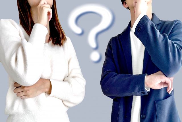 結婚相談所埼玉　並んで立ち、考え事をしているポーズをとった若い男女の間に「？」マークがある画像です。