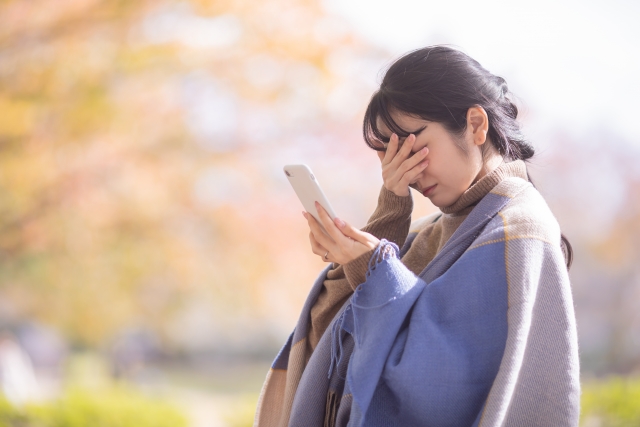 結婚相談所埼玉　携帯電話を片手に悩む女性