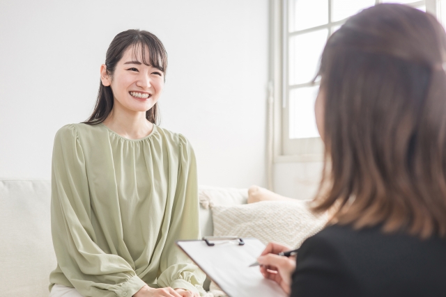 結婚相談所埼玉　若い女性が笑顔で話をしている。手前に相手の女性の後ろ姿の画像です。