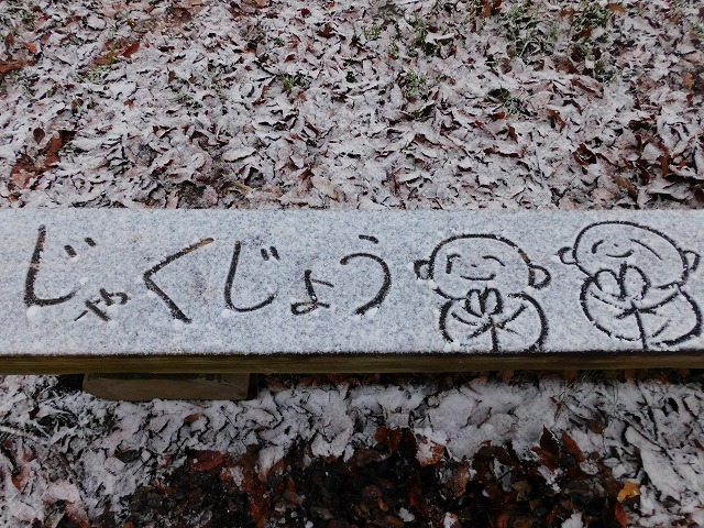 結婚相談所埼玉　嵐山町の雪　嵐山町歴史資料館のベンチに雪がつもり寂静先生がお地蔵さまのイラストを描いた写真です。