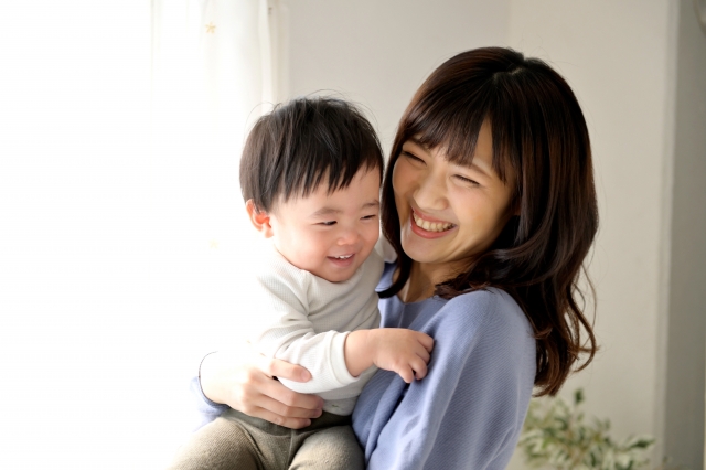 結婚相談所埼玉　赤ちゃんを抱っこしている若いお母さん、ふたりとも笑顔の写真です。