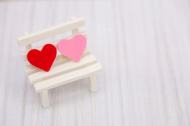 結婚相談所埼玉　小さなベンチにピンク色と赤色のハートが並んで置かれている画像です。