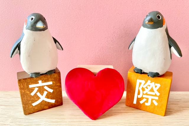 結婚相談所埼玉　真ん中に赤いハートが置いてあり、ハートの左右に「結」「婚」と書かれた木製のキューブに乗ったペンギンの置物がある画像です。