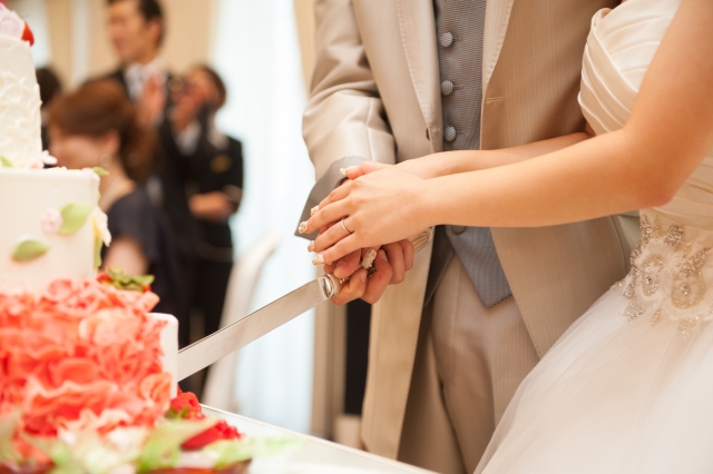 結婚相談所埼玉 披露宴で、新郎新婦がケーキ入刀をしているシーンの画像です。